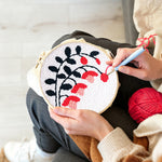 Creating handmade black branches with pink and red blooms punch needle artwork