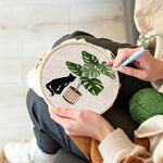 Creating handmade black cat and monstera plant punch needle artwork