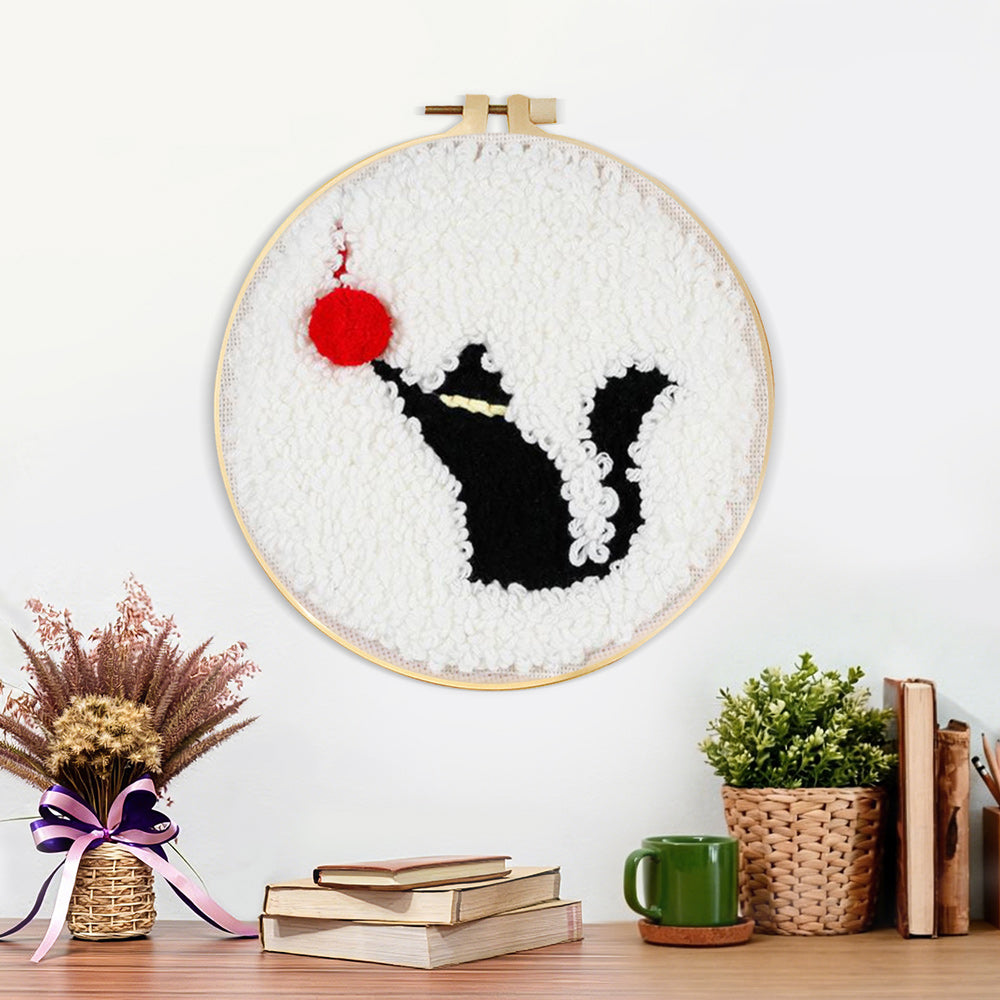 Finished black cat and red ball of yarn artwork displayed on a wall