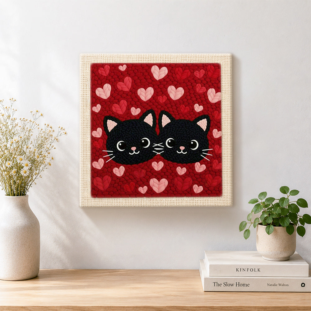 Finished black cat couple surrounded by hearts artwork displayed on a wall