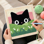 Creating handmade black cat in green meadow punch needle artwork