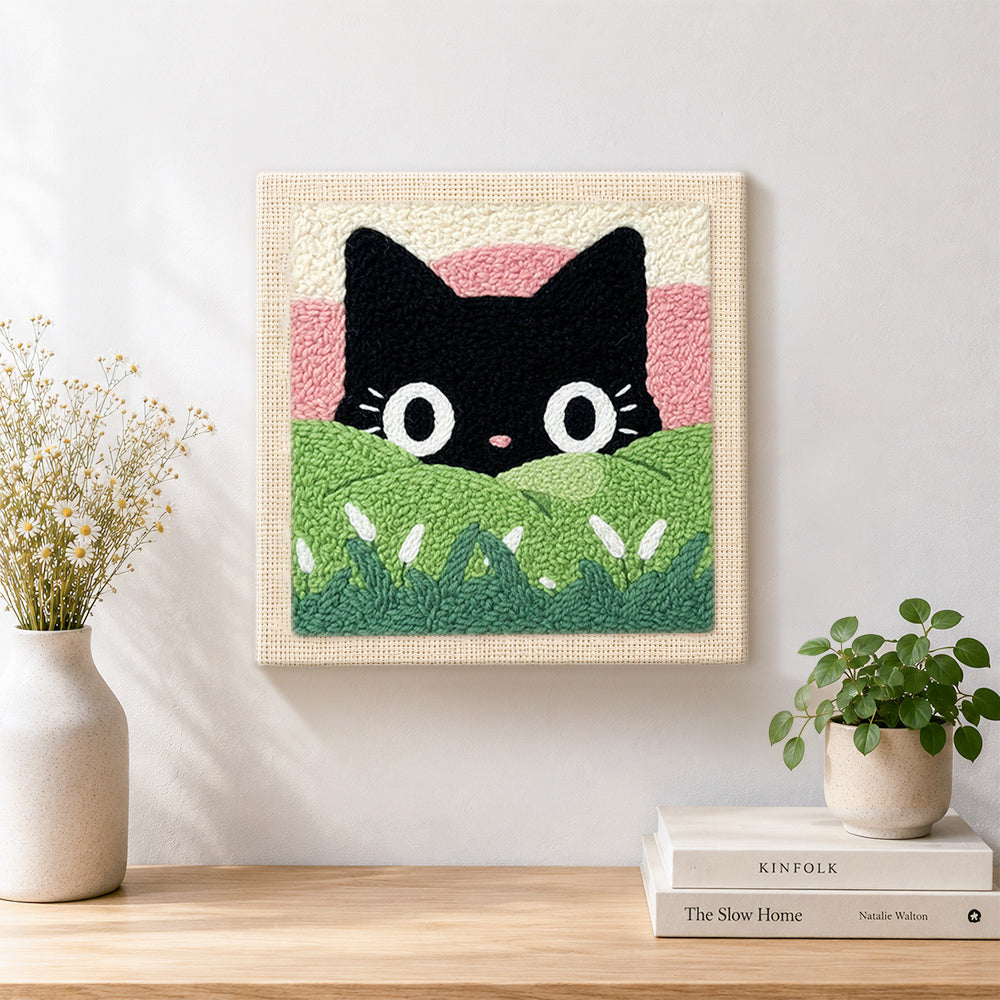 Finished black cat in green meadow artwork displayed on a wall