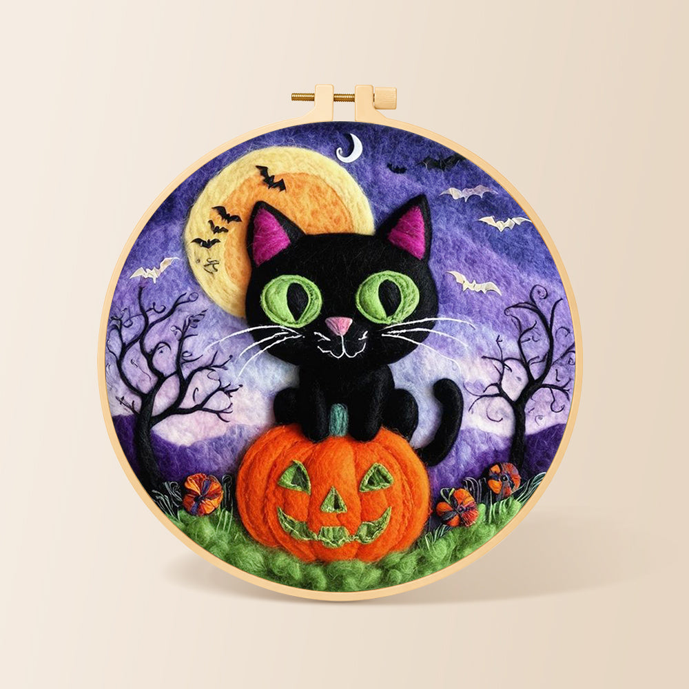 Black cat with green eyes on pumpkin needle felting kit for beginners with a round wooden frame