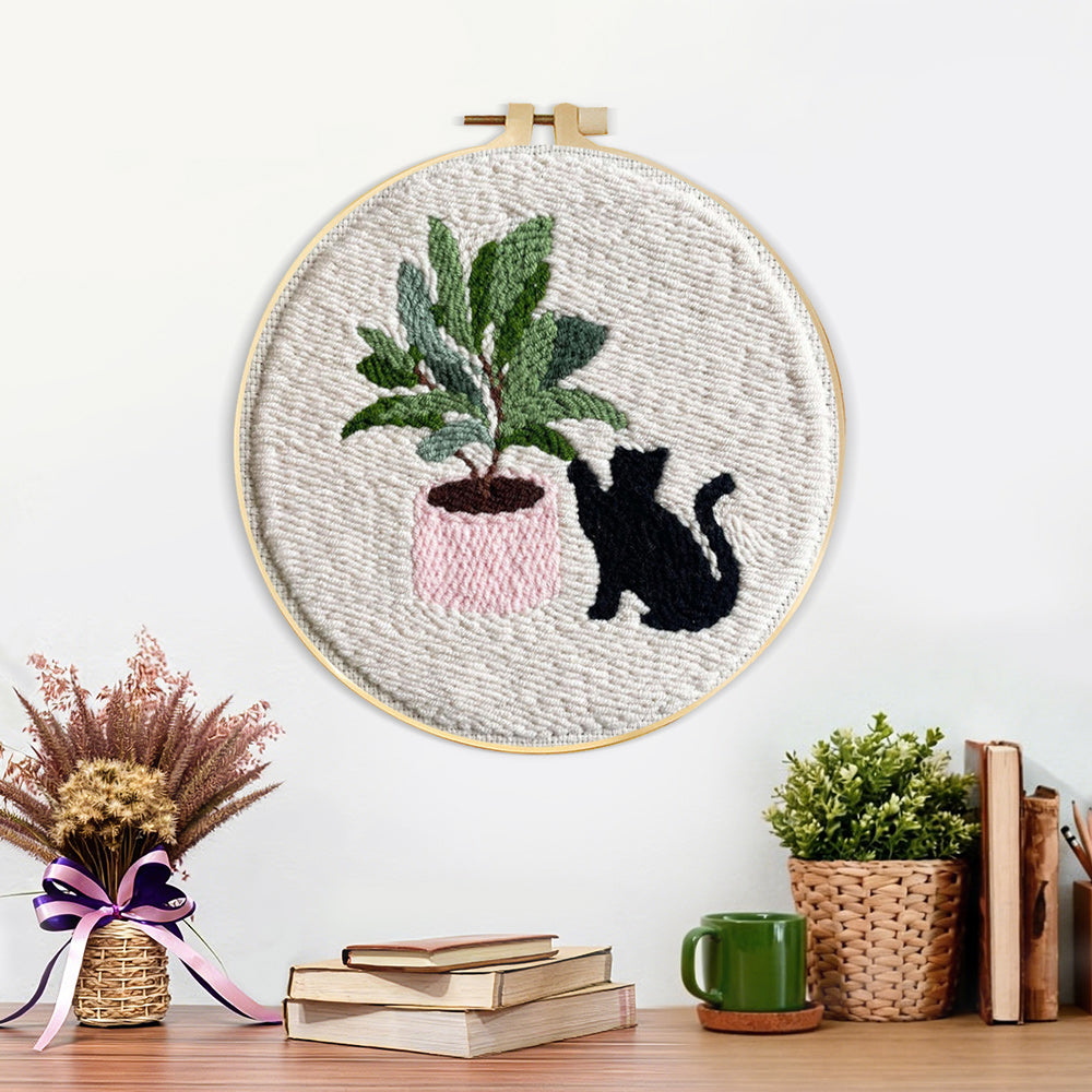 Finished black cat with houseplant artwork displayed on a wall