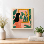 Finished black hair woman, tropical leaves and framed banana artwork displayed on a wall