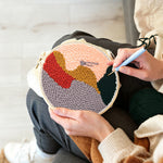 Creating handmade blonde woman in red hat punch needle artwork