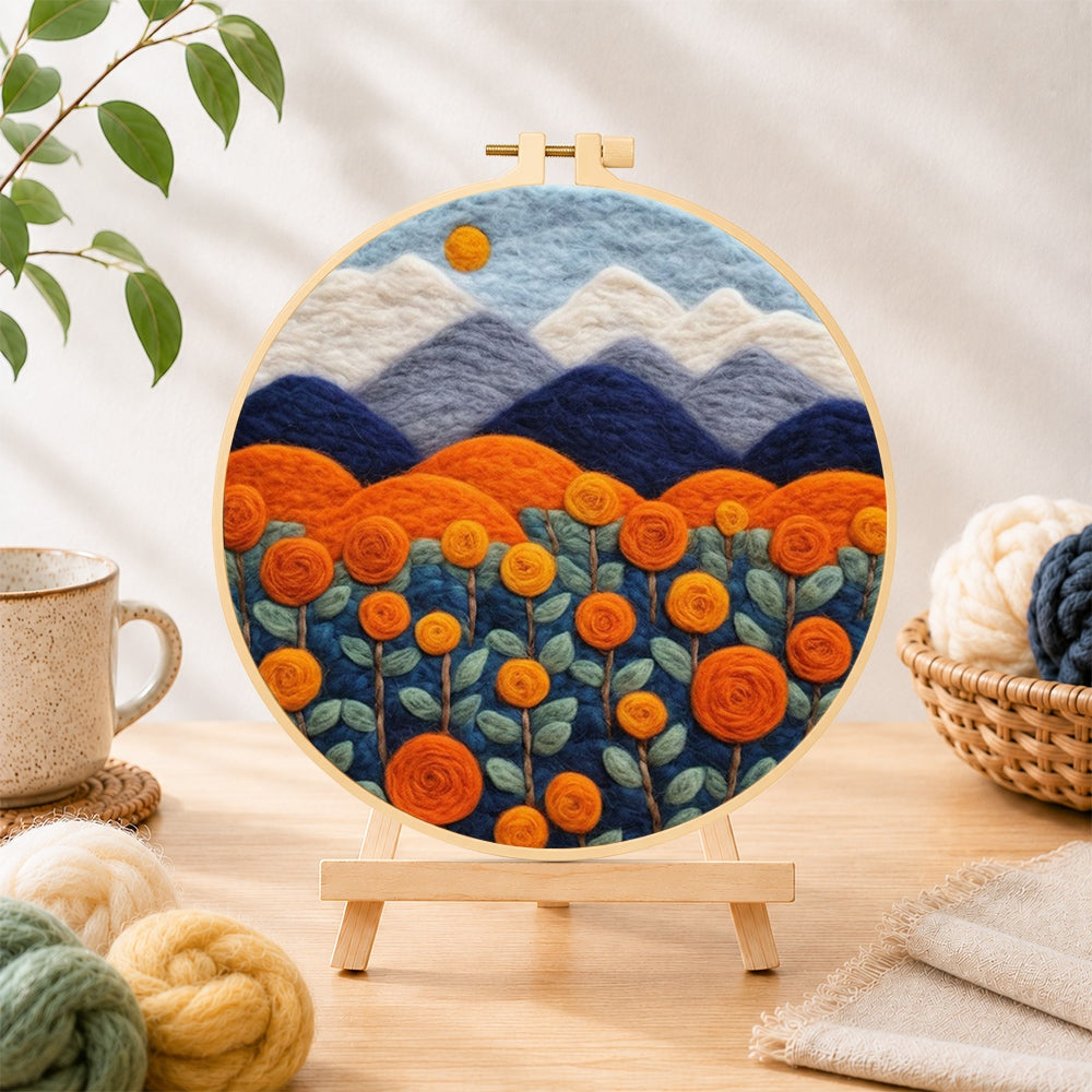 Finished blooming orange roses and mountains needle felting displayed on a wooden easel