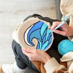 Creating handmade blue and teal rolling wave with beige sky punch needle artwork
