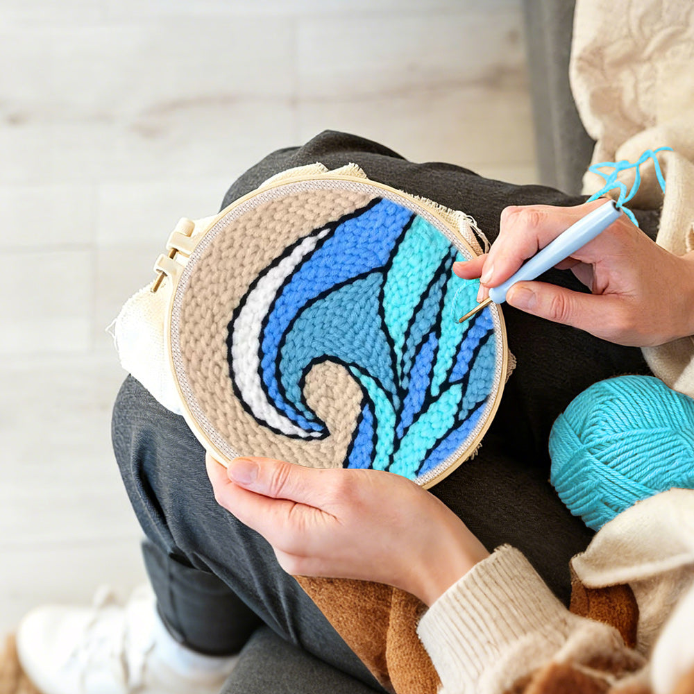 Creating handmade blue and teal rolling wave with beige sky punch needle artwork