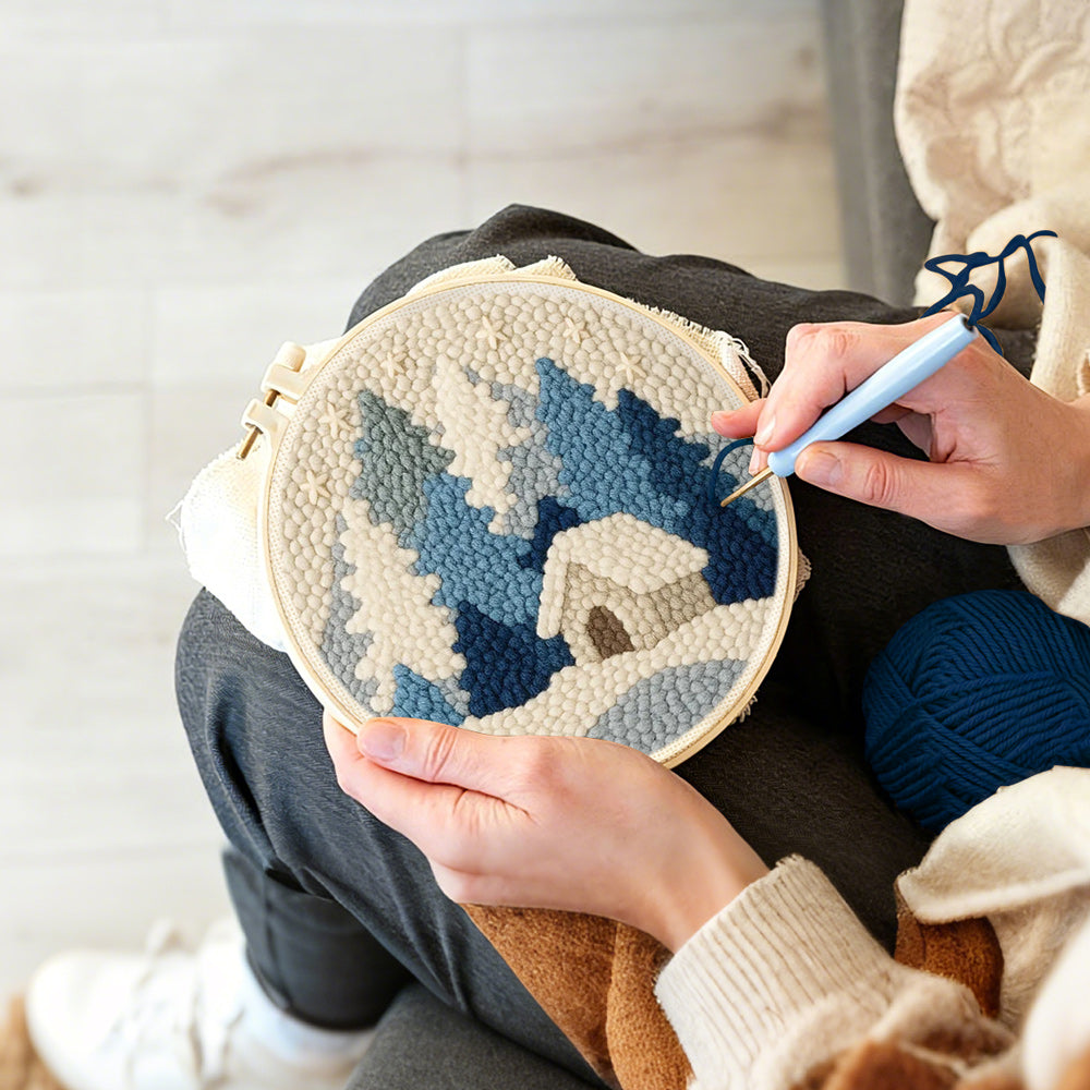 Creating handmade blue and white snowy cabin in the woods punch needle artwork