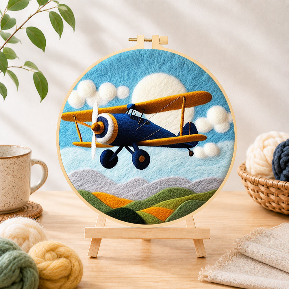 Finished blue biplane flying needle felting displayed on a wooden easel
