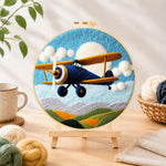 Finished blue biplane flying needle felting displayed on a wooden easel