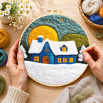 Creating the blue cottage under the big yellow moon wool painting by hand with a felting needle