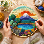 Creating the blue lake, green trees and snow mountain wool painting by hand with a felting needle