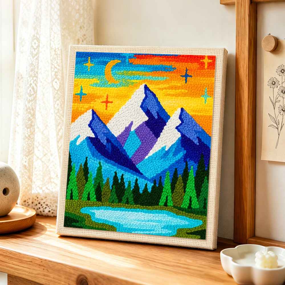 Blue mountains under the dreamy starry night punch needle artwork displayed on a table