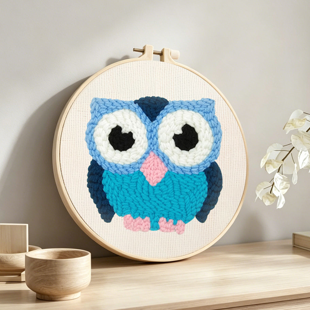 Blue owl punch needle artwork displayed on a table