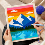 Creating handmade blue peaks and lake reflection punch needle artwork