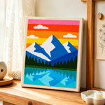 Blue Peaks and Lake Reflection punch needle artwork displayed on a table