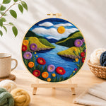 Finished blue river and enchanting poppies needle felting displayed on a wooden easel