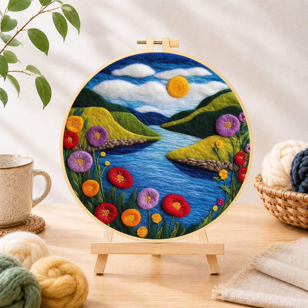 Finished blue river and enchanting poppies needle felting displayed on a wooden easel