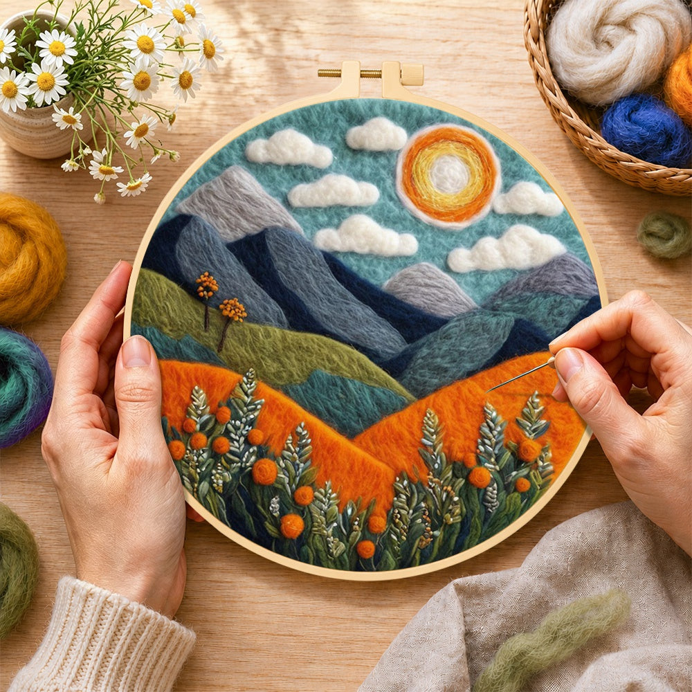 Creating the blue terrain under the sun wool painting by hand with a felting needle