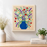 Finished blue vase with lavender, daisies and poppies artwork displayed on a wall