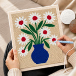 Creating handmade blue vase with red-centred daisies punch needle artwork