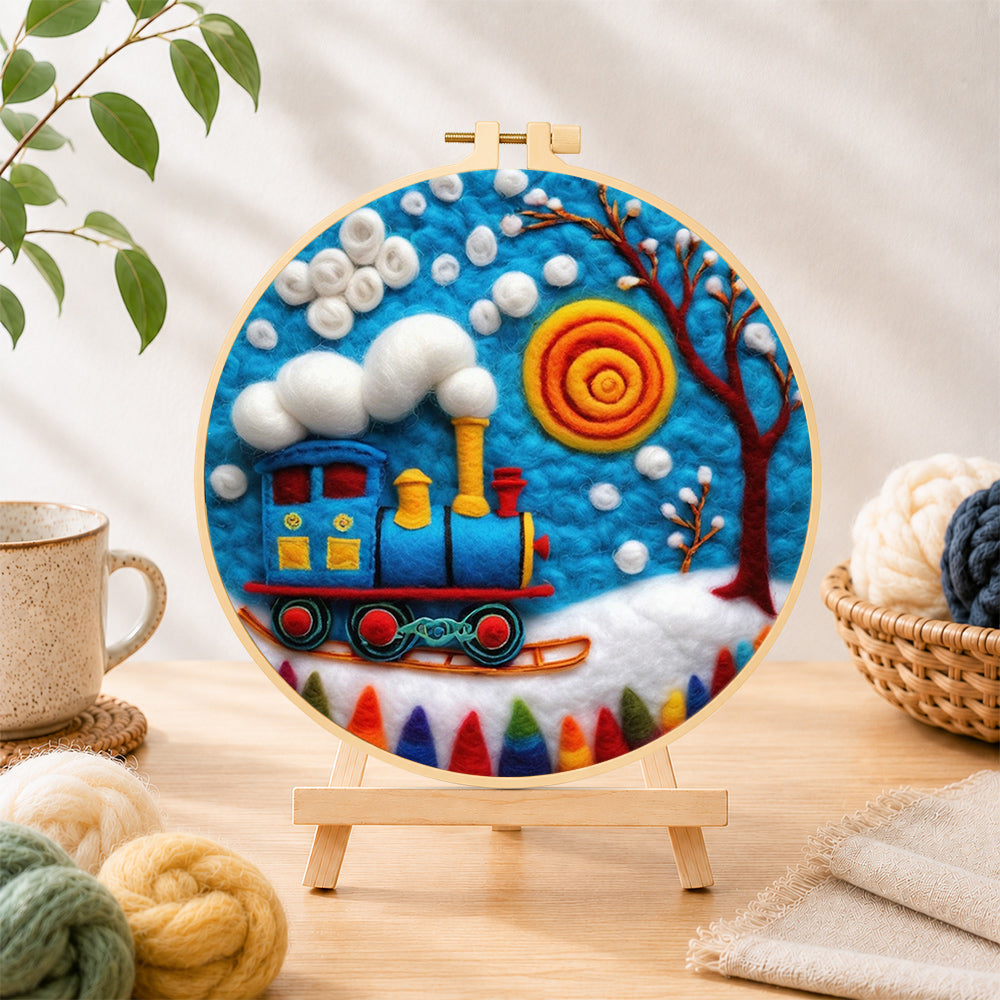 Finished blue winter train with swirling sun needle felting displayed on a wooden easel