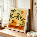 Boho leaves, oranges and sun punch needle artwork displayed on a table