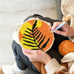 Creating handmade bold black and yellow leaf punch needle artwork