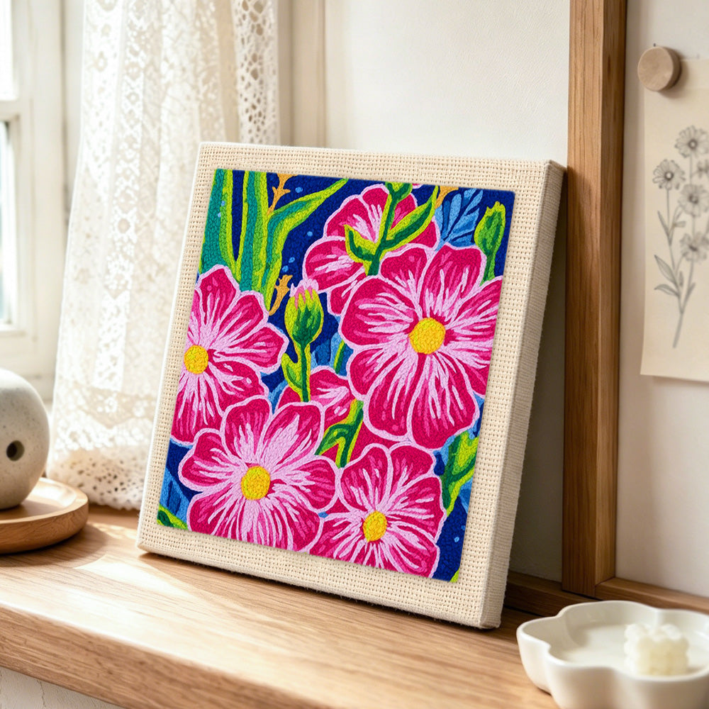 Bold pink tropical flowers punch needle artwork displayed on a table