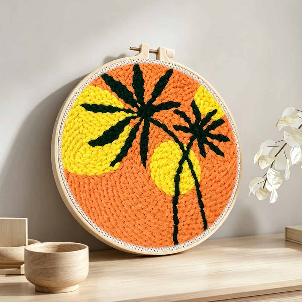 Bold sunset palm silhouette punch needle artwork displayed on a table