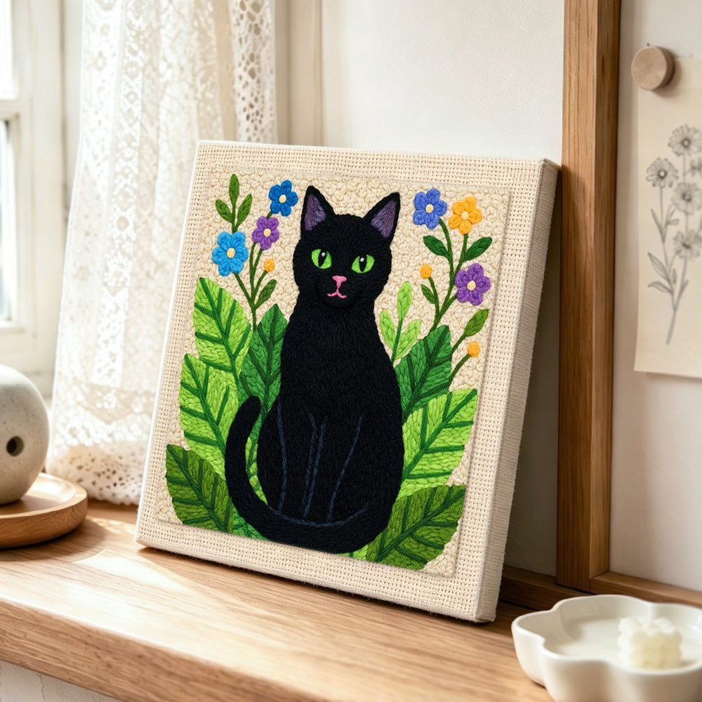 Botanical black cat punch needle artwork displayed on a table
