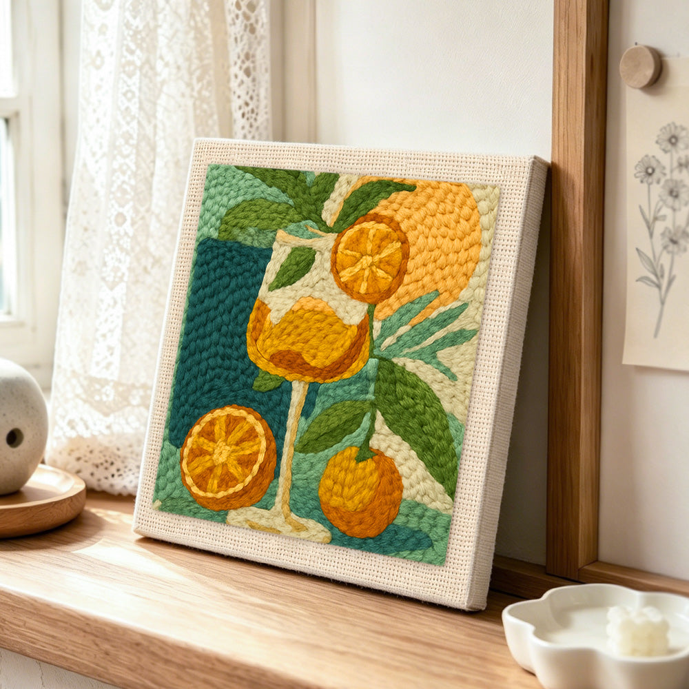 Botanical citrus drink punch needle artwork displayed on a table