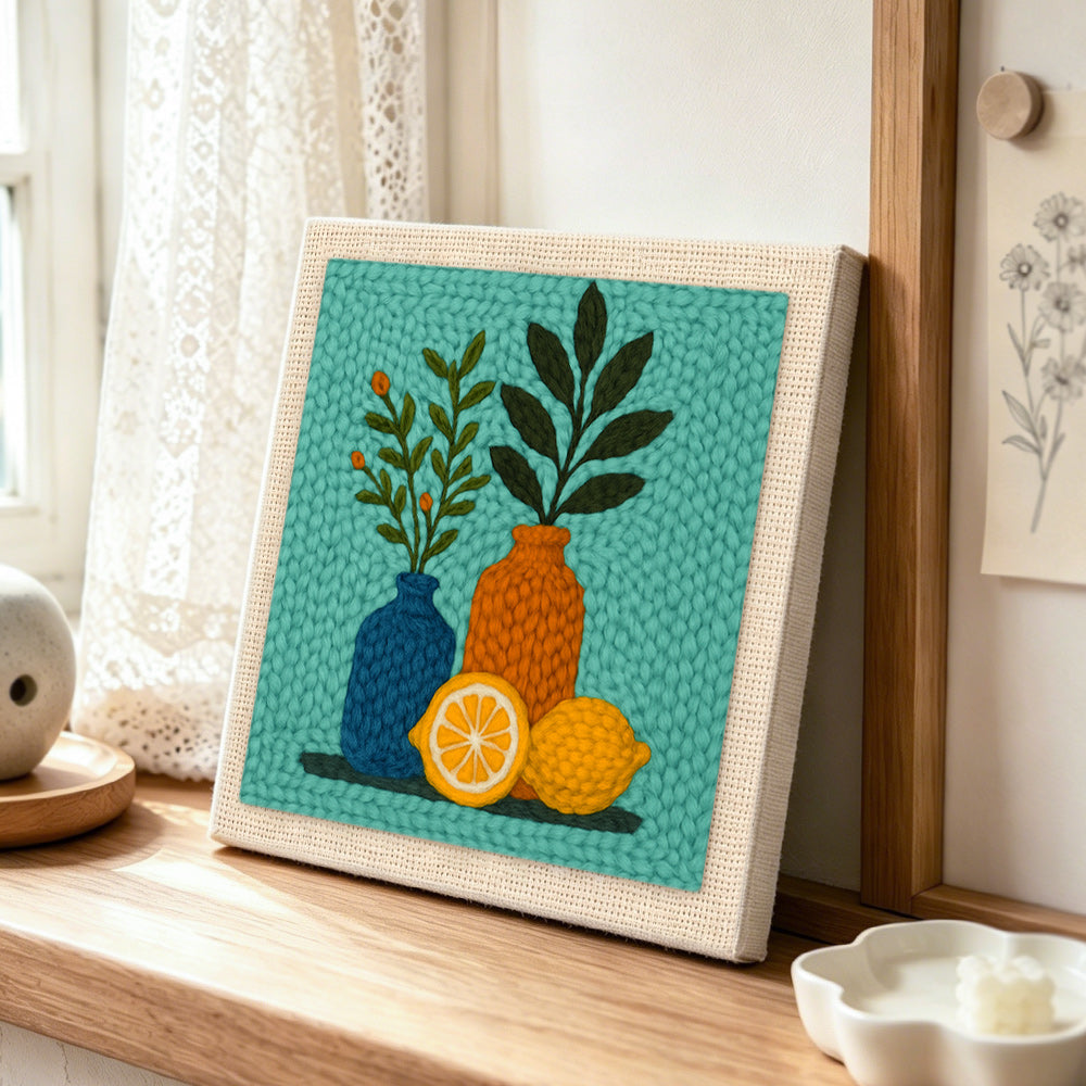 Botanical still life punch needle artwork displayed on a table