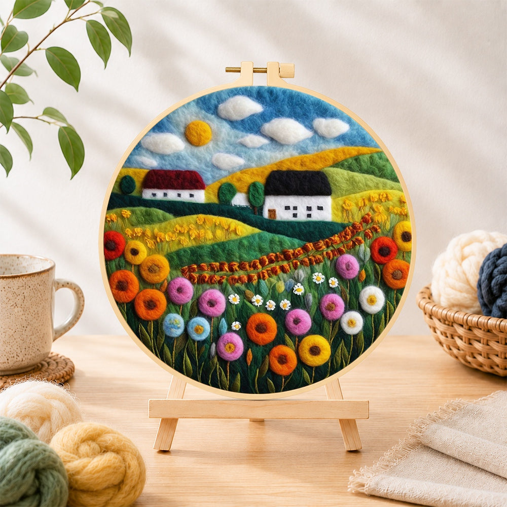 Finished bountiful wildflower field and summer cottage needle felting displayed on a wooden easel