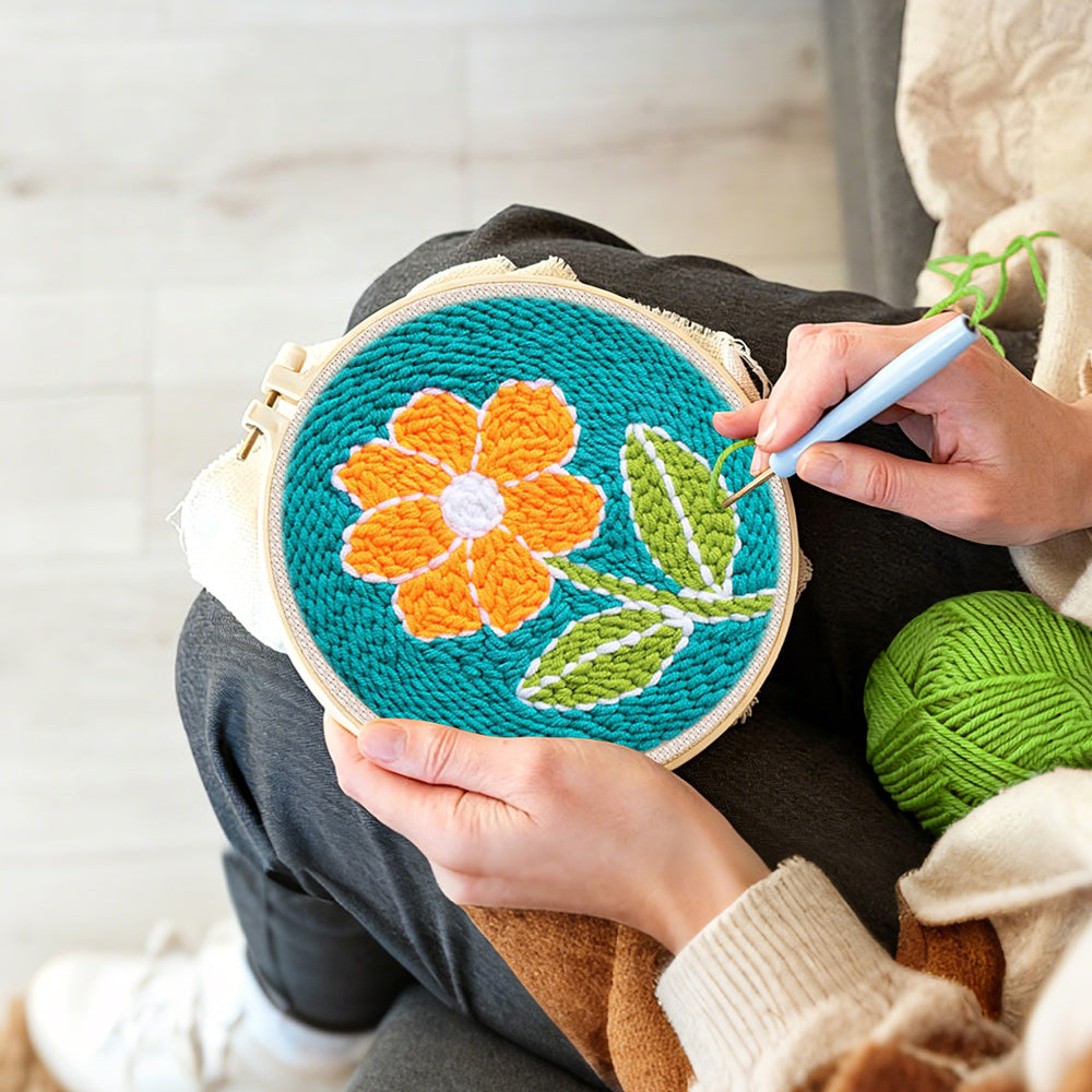 Creating handmade bright orange flower punch needle artwork