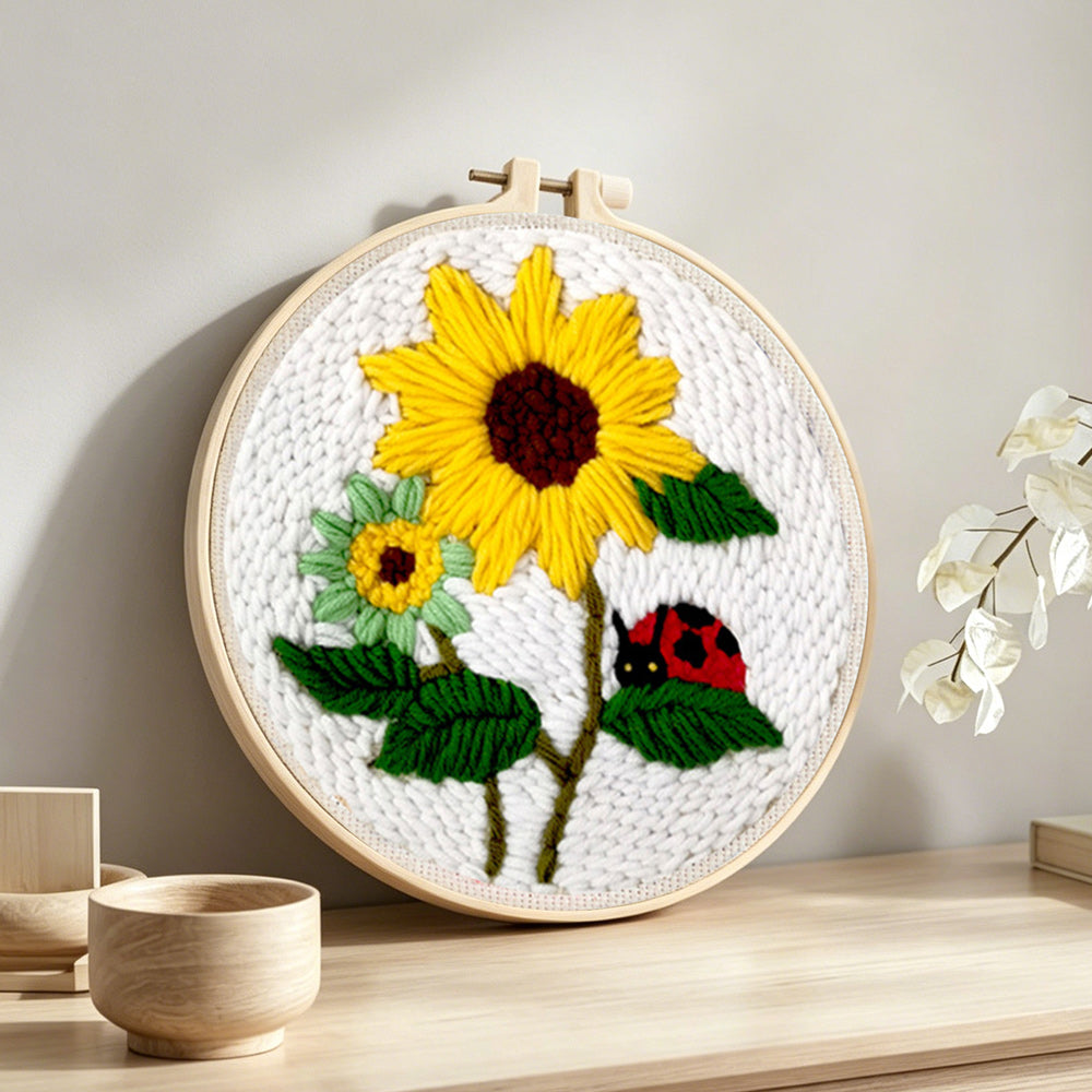 Bright summer sunflowers and ladybug punch needle artwork displayed on a table