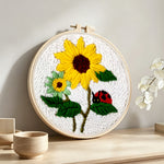 Bright summer sunflowers and ladybug punch needle artwork displayed on a table