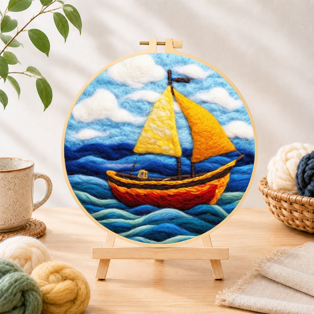 Finished bright yellow sailboat on blue waves needle felting displayed on a wooden easel