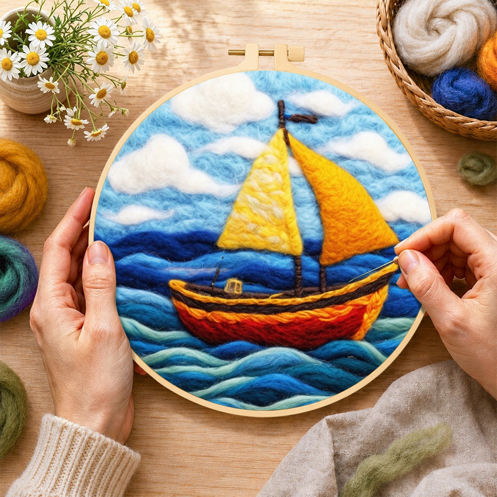 Creating the bright yellow sailboat on blue waves wool painting by hand with a felting needle