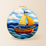 Bright yellow sailboat on blue waves needle felting kit for beginners with a round wooden frame