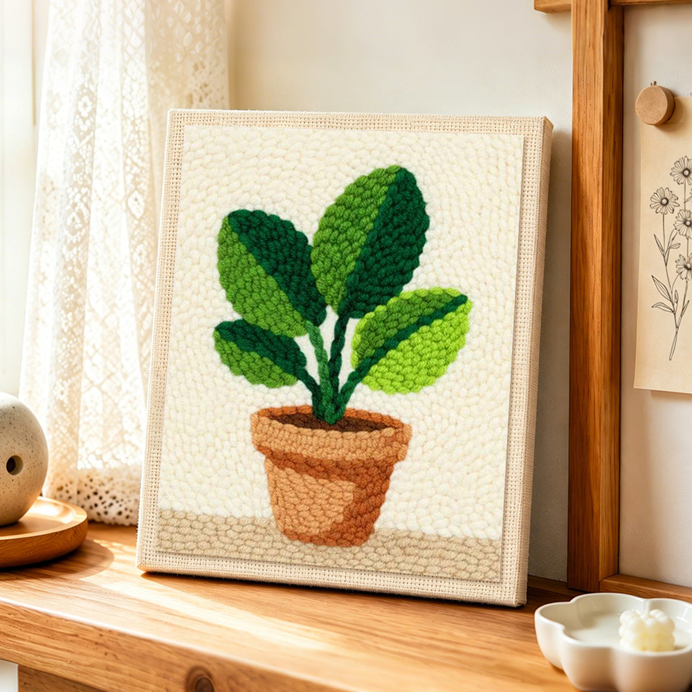 Broad leaf potted plant punch needle artwork displayed on a table