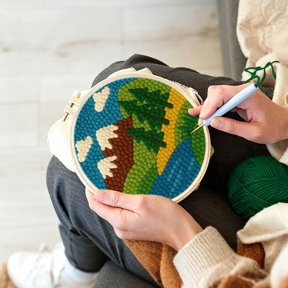 Creating handmade brown mountains and pine trees by the river punch needle artwork