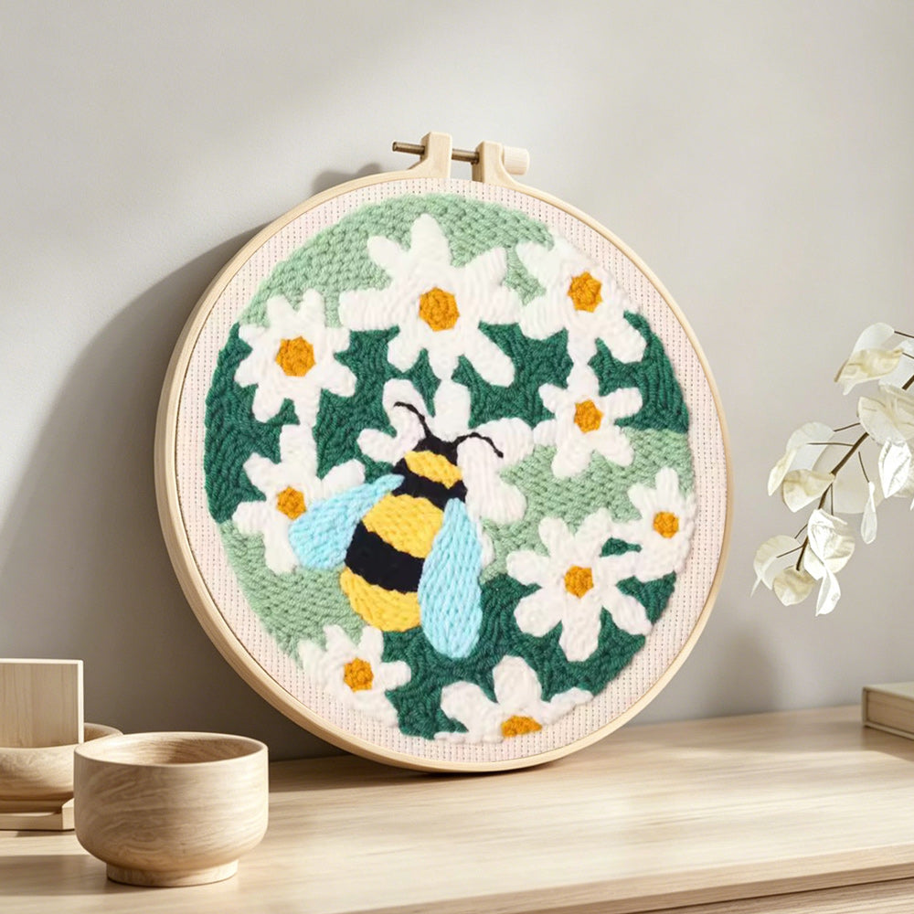 Bumblebee among white daisies punch needle artwork displayed on a table