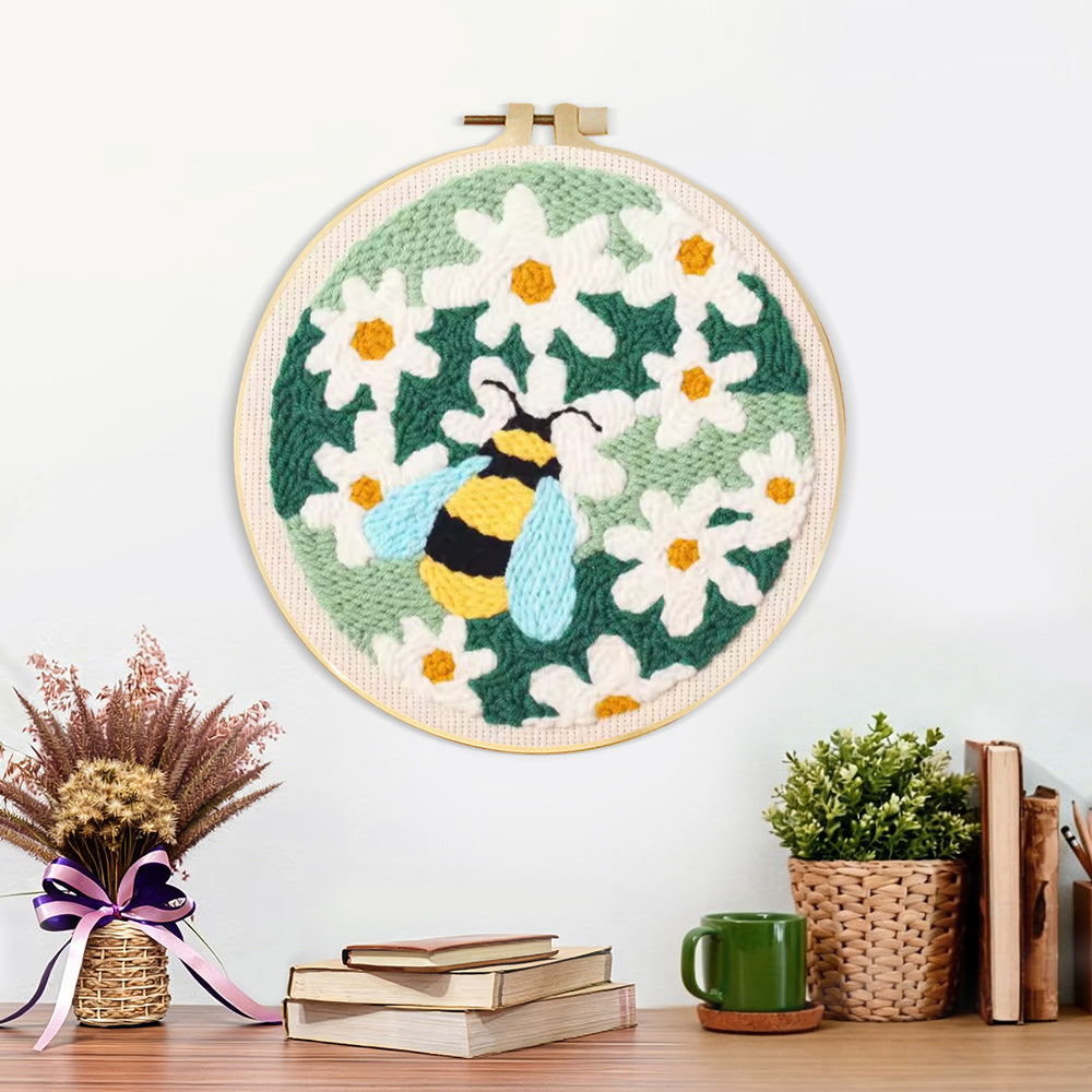 Finished bumblebee among white daisies artwork displayed on a wall