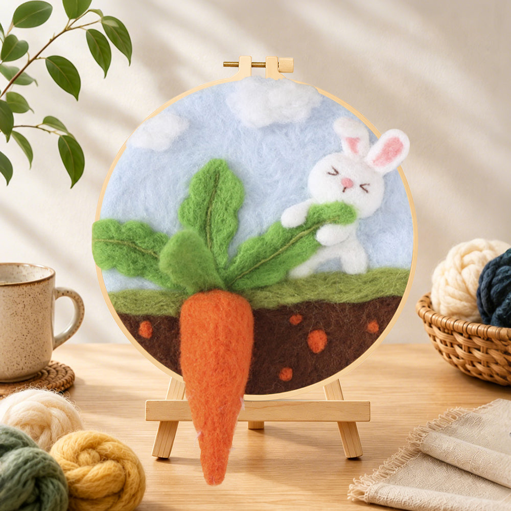 Finished bunny pulling a giant carrot needle felting displayed on a wooden easel