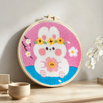 Bunny with flowers punch needle artwork displayed on a table