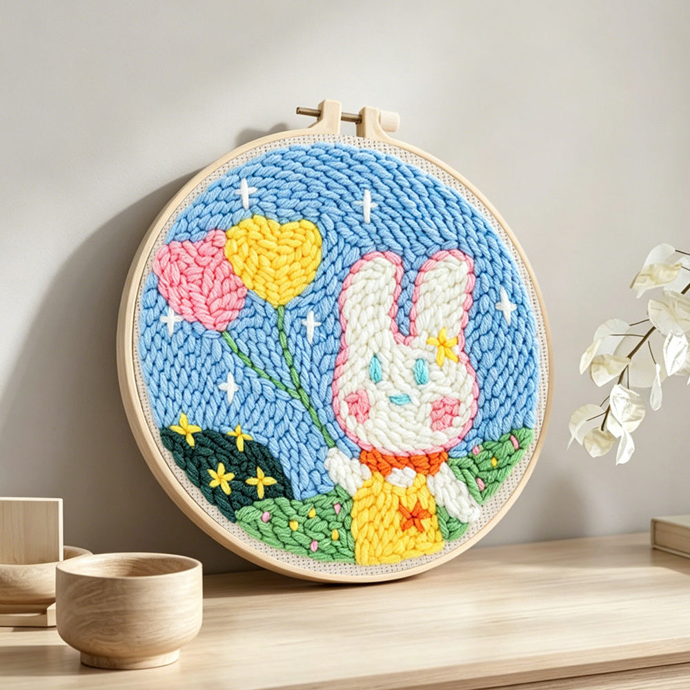Bunny with heart-shaped balloons punch needle artwork displayed on a table