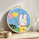 Bunny with heart-shaped balloons punch needle artwork displayed on a table